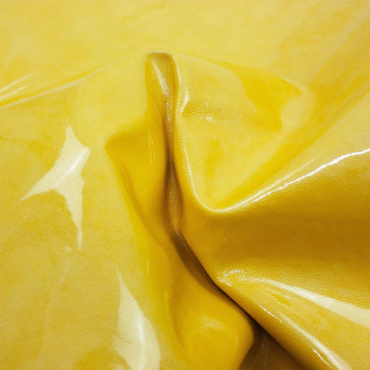 Piece of wrinkled, aged yellow patent leather